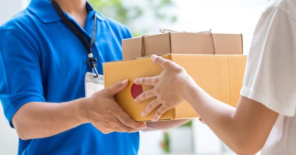 Woman hand accepting a delivery of boxes from deliveryman