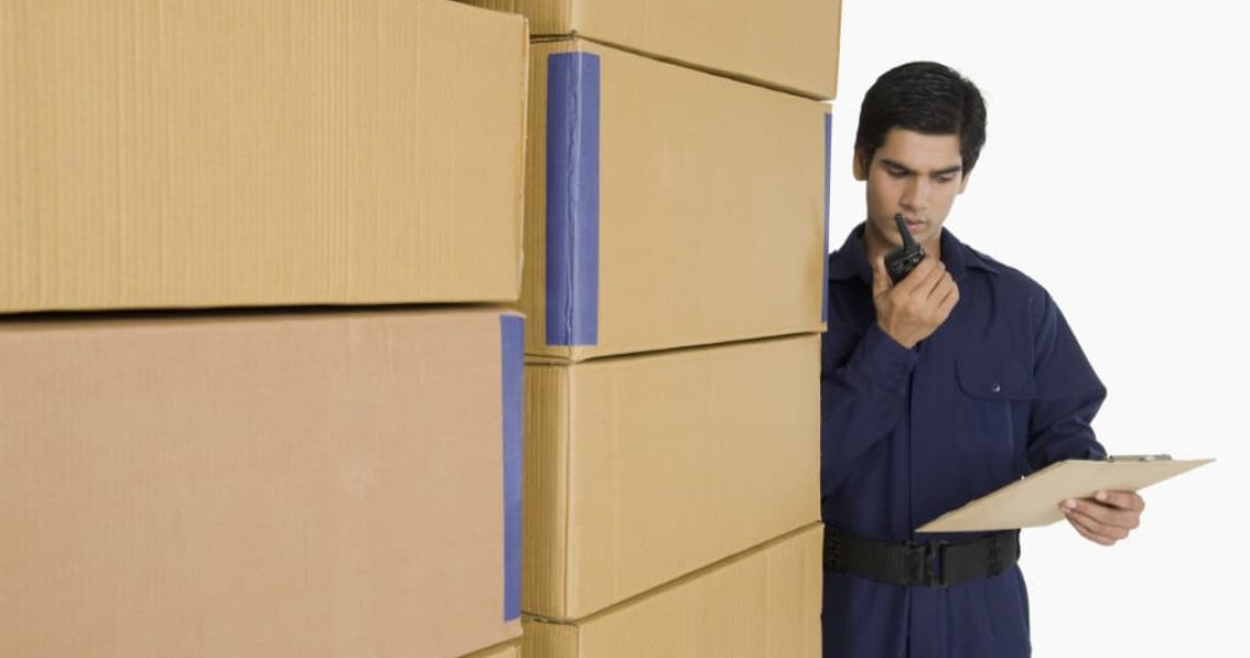 Store incharge talking on a walkie-talkie in a warehouse